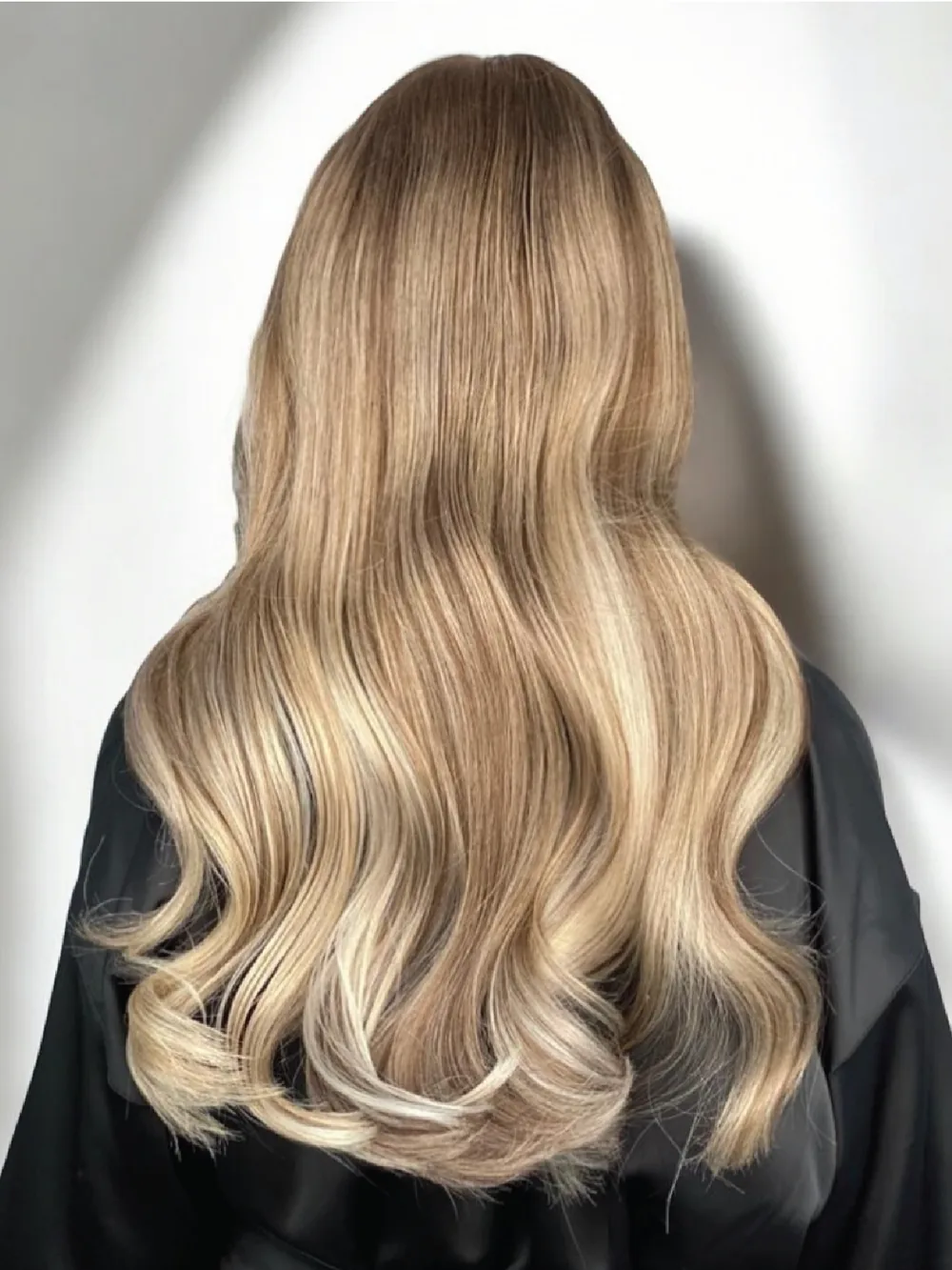 Long, softly waved hair with bright, blended blonde highlights